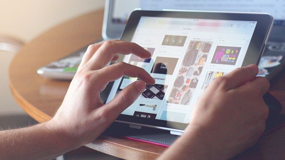 Tablet das in den Händen gehalten wird beim shoppen